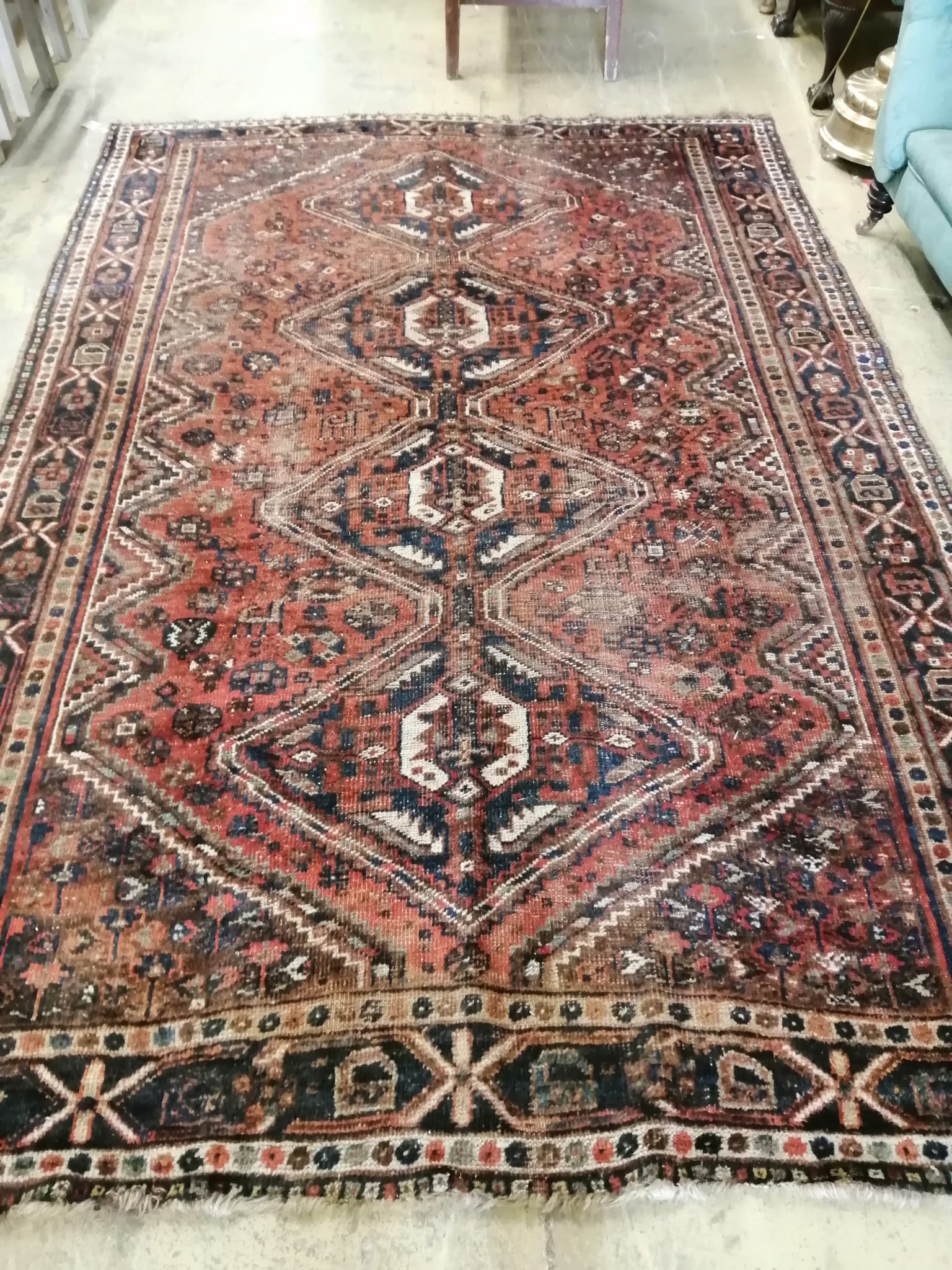 A Caucasian red ground carpet with geometric field, 290 x 207cm